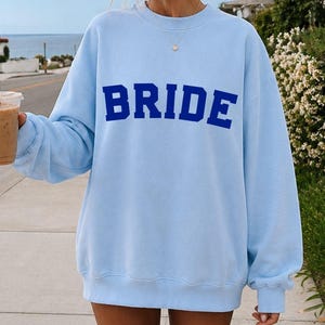 Bride Crewneck Bridal Sweatshirt Engaged gift for her custom mrs shirt announce engagement personalized wifey get married custom engaged shirt bride getting ready outfit future mrs engaged just engaged gift just married shirt bride hoodie mrs hoodie wifey sweatshirt bride mrs sweatshirt. bride clothes, wedding newly engaged gift. This is a custom bride crewneck bridal sweatshirt. It's a gildan 18000 crewneck sweatshirt.