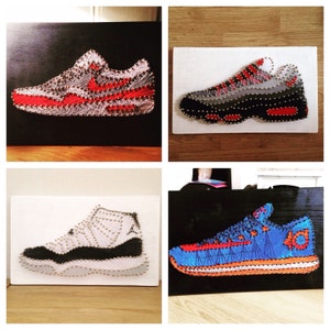 May include: Four different string art pieces of sneakers. The first is a red and white Air Max 1, the second is a grey and red Air Max 95, the third is a white and black Air Jordan 11, and the fourth is a blue and orange KD 6.