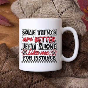 May include: White ceramic mug featuring the quote "SOME THINGS are BETTER LEFT ALONE like me, FOR INSTANCE." The text is in various fonts and colours, including black, red, and white. The mug has a curved handle.