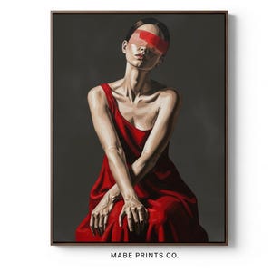 May include: A framed art print featuring a woman in a red dress with a red band over her eyes. The painting has a dark, moody aesthetic. The artwork is signed "MABE PRINTS CO."