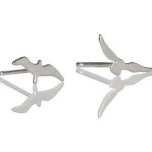 Peut inclure: Une paire de boucles d'oreilles en argent en forme d'oiseau en vol. Les boucles d'oreilles sont simples et élégantes.