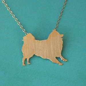 Op de afbeelding: Een zilveren ketting met een geborsteld metalen hanger in de vorm van een silhouet van een Pommeren.