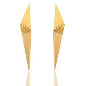 Könnte beinhalten: Ein Paar goldfarbene Ohrringe mit geometrischem, spitzem Design.