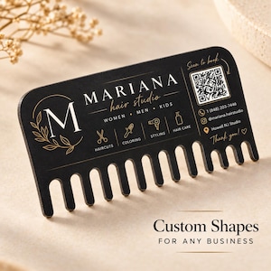 May include: A black business card shaped like a wide-tooth comb with gold text and graphics. It features the text Mariana Hair Studio, a QR code, phone number, social media handle, and location. Icons represent haircuts, coloring, styling, and hair care.