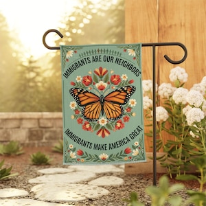 Könnte beinhalten: Eine rechteckige Gartenflagge mit hellgrünem Hintergrund, einem zentralen orange-schwarzen Monarchfalter und roten sowie weißen Blumen. Der Text lautet IMMIGRANTS ARE OUR NEIGHBORS und IMMIGRANTS MAKE AMERICA GREAT.