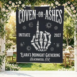 May include: A black rectangular banner featuring the white text COVEN OR ASHES at the top, a central graphic of a skeleton hand making a middle finger gesture, and the text INITIATE 2027, ELARA'S MIDNIGHT GATHERING, and BLACKWATER, OR below.