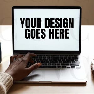 May include: A laptop displaying "YOUR DESIGN GOES HERE" on the screen. Hands are using the keyboard and mouse. A coffee mug, a small potted plant, and a notebook are on the table. A red "INSTANT DOWNLOAD" stamp is in the corner.