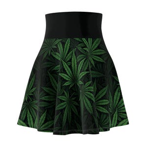 May include: A skater skirt featuring a high waistband and a flared silhouette. The skirt is adorned with a repeating pattern of green cannabis leaves against a dark background. The waistband is solid black.