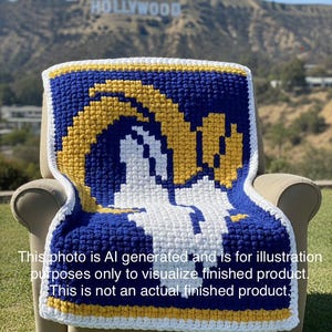 May include: A handmade crochet blanket featuring the Los Angeles Rams logo in blue, white, and yellow. The blanket is draped over a chair outdoors with the Hollywood sign in the background. The blanket is a cozy home decor item.