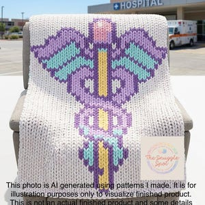 May include: A thick, knitted blanket with a large, colourful design draped over a chair. The design features a central yellow staff with purple, teal, and pink accents. The blanket is white with a large, colourful design. The background includes a hospital and an ambulance.