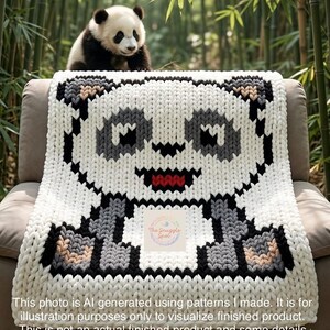 May include: A white, gray, black, and red panda bear design blanket. The blanket is draped over a chair, with a real panda bear sitting on top. The blanket has a pixelated design. The text on the image says: "The Snuggle Spot".