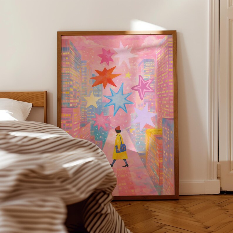 May include: A framed art print depicts a person walking down a city street, surrounded by tall buildings and colorful starbursts. The artwork features a pink and purple color palette, with a wooden frame.