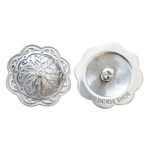 May include: Silver-toned metal concho with a floral design on the front and the words "HORSE SHOE" engraved on the back.