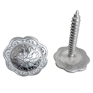 Può includere: Due chiodi decorativi in metallo argentato con un motivo floreale. Il chiodo a destra ha una vite e una base piatta con le parole "HORSE SHOE" incise.