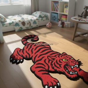 May include: A red and black tiger-shaped rug with a detailed design. The rug features black stripes on a red background, with yellow eyes and white teeth. The rug is placed on a wooden floor.