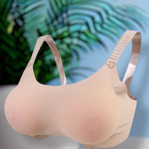 May include: A beige seamless bra featuring molded cups with a subtle textured finish, a scoop neckline, and wide, adjustable shoulder straps with a ribbed design. The garment is constructed from a smooth, solid-colored fabric with a contoured shape.
