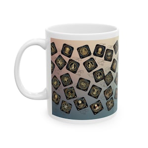 以下が含まれることがあります： グラデーションの背景に、正方形の金色のイラストが繰り返される模様が特徴の白いセラミックコーヒーマグ。イラストは天体または占星術をテーマにしているようです。マグには湾曲したハンドルが付いています。