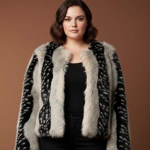 May include: A faux fur jacket featuring a bold design of vertical black and white stripes. The jacket has a collarless design and long sleeves. The color palette includes black, white, and light grey. A stylish outerwear garment.