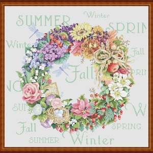 May include: A wreath made of various flowers and greenery, including roses, lilies, and sunflowers. The wreath is decorated with the words "Summer", "Winter", "Spring", and "Fall" around the wreath.