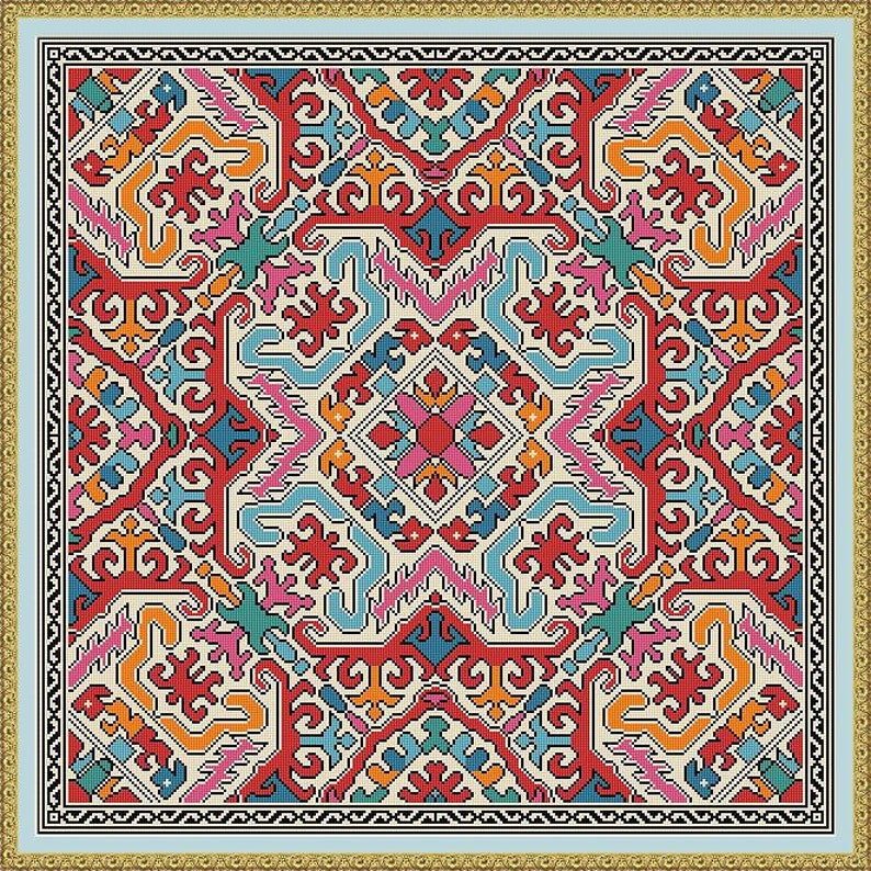 K&ouml;nnte beinhalten: Ein quadratisches, gemustertes Textil mit hellblauem Rand und goldfarbenem Rahmen. Das Design zeigt eine symmetrische Anordnung von roten, orangen, blauen, rosa und gr&uuml;nen geometrischen Formen auf cremefarbenem Hintergrund. Das Muster ist komplex und detailliert.