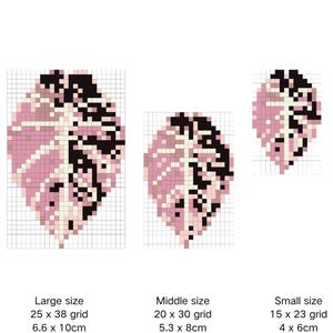 Op de afbeelding: Drie gepixelde bladontwerpen in verschillende maten, elk met een roze, zwart en crèmekleurig kleurenschema. De tekst bovenaan luidt "Alocasia reginula 'Black Velvet Pink'". De maten zijn gelabeld als groot (6,6 x 10cm), middel (5,3 x 8cm) en klein (4 x 6cm).
