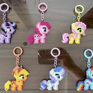 May include: A white ceramic mug with a black handle and the text "But First, Coffee" in a handwritten style. The mug is on a white surface. The mug is approximately 4 inches tall.