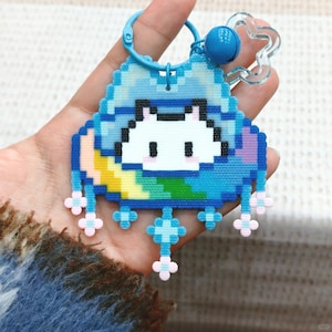 Op de afbeelding: Een set van drie keramische mokken met een gespikkelde, matte afwerking. De mokken zijn in crème, lichtgrijs en donkergrijs. Elke mok heeft een eenvoudig, minimalistisch ontwerp.