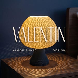 Peut inclure: Une lampe de table moderne avec un abat-jour jaune tissé et une base noire. La lampe projette une lumière à motifs sur la table de chevet en bois. Le texte sur la lampe indique "VALENTIN ALGORITHMIC DESIGN". Les mots "MODERN ACCENT LIGHTING" sont en haut.