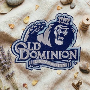 May include: Embroidered patch featuring the Old Dominion University lion mascot in navy blue, light blue, and gray. The patch includes the words "Old Dominion University" in a stylized font, suitable for apparel or accessories.