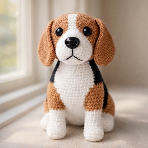 May include: A crocheted beagle dog with brown, white, and black details. The handmade stuffed animal has large black eyes, floppy ears, and is sitting upright. The dog's body is primarily white with brown patches.