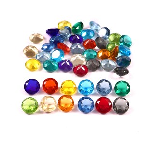 May include: A selection of multi-coloured faceted gemstones, including blue, red, yellow, green, and clear. The gemstones are scattered on a white surface, displaying their different shapes and sizes. Suitable for jewellery making or craft projects.