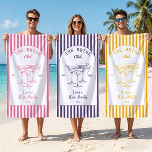 Op de afbeelding: Drie rechthoekige strandhanddoeken met verticale strepen in roze, paars en geel. Elke handdoek toont een centraal boogontwerp met de tekst THE BRIDE Club, Est 2026, Liora's Hen Party en Ibiza, vergezeld van illustraties van drie martiniglazen.