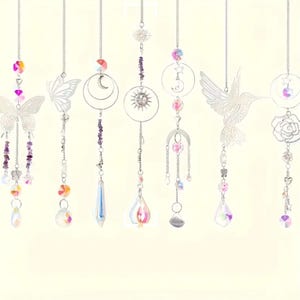 May include: Seven hanging suncatchers featuring silver-toned metal charms including butterflies, a hummingbird, a rose, a sun, and moons. Each ornament is suspended by a silver chain and decorated with colorful glass beads and clear crystal prisms.
