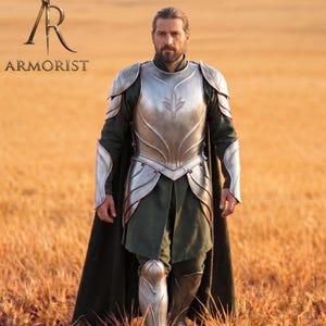 May include: A person wearing silver armour with a leaf design on the chest plate, green tunic, and black cape. The armour is detailed with silver accents. The word "ARMORIST" is printed above the person.