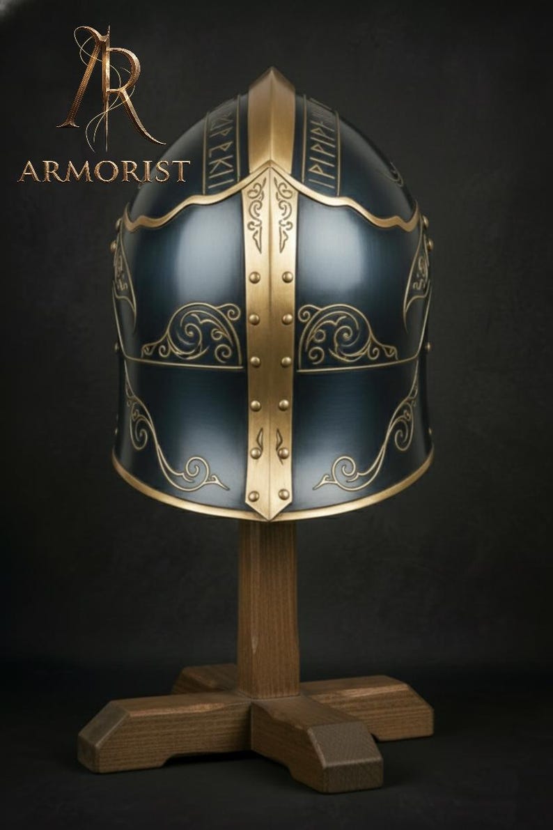 K&ouml;nnte beinhalten: Dunkelblauer Helm mit goldenen Akzenten und dekorativen Schn&ouml;rkeln, pr&auml;sentiert auf einem Holzst&auml;nder. Der Helm hat goldene Verzierungen und Nieten, mit Text oben. Das Wort "ARMORIST" ist in goldenen Buchstaben zu sehen.