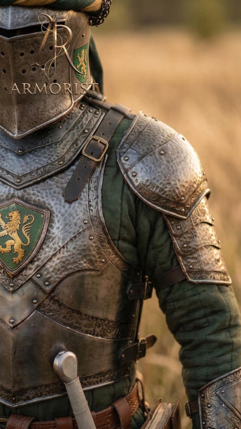 K&ouml;nnte beinhalten: Nahaufnahme einer mittelalterlichen R&uuml;stung mit einem gr&uuml;nen und goldenen L&ouml;wenwappen. Die R&uuml;stung ist silberfarben mit aufwendigen Details und Lederriemen. Der Text "ARMORIST" ist auf dem Helm zu sehen. Der Hintergrund ist ein verschwommenes Feld.
