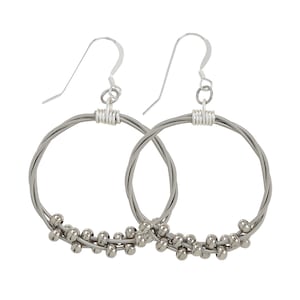 May include: Silver hoop earrings made from guitar strings with silver beads.