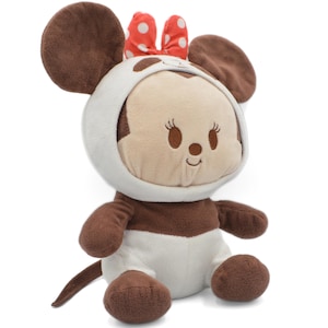 May include: A plush toy of a cartoon character, featuring a brown and white color scheme. The toy has large, round ears, a red bow with white polka dots, and a smiling face. The toy is sitting upright.