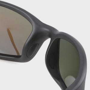 Puede incluir: Primer plano de gafas de sol negras con montura curvada. Las lentes tienen un acabado reflectante y espejado con tonos dorados y verdes. El dise&ntilde;o presenta una est&eacute;tica elegante y moderna.