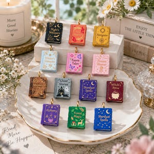 May include: A collection of twelve miniature book-shaped charms in various colors, each featuring unique titles and illustrations including Night's Whispers, Fire Starter, Navigator, Winter's Grimoire, Faerie Tales, Dream Weaver, Adventure Log, Ghost Stories, Stardust Spells, Witch's Brew, Alchemy, and Forest Magic.