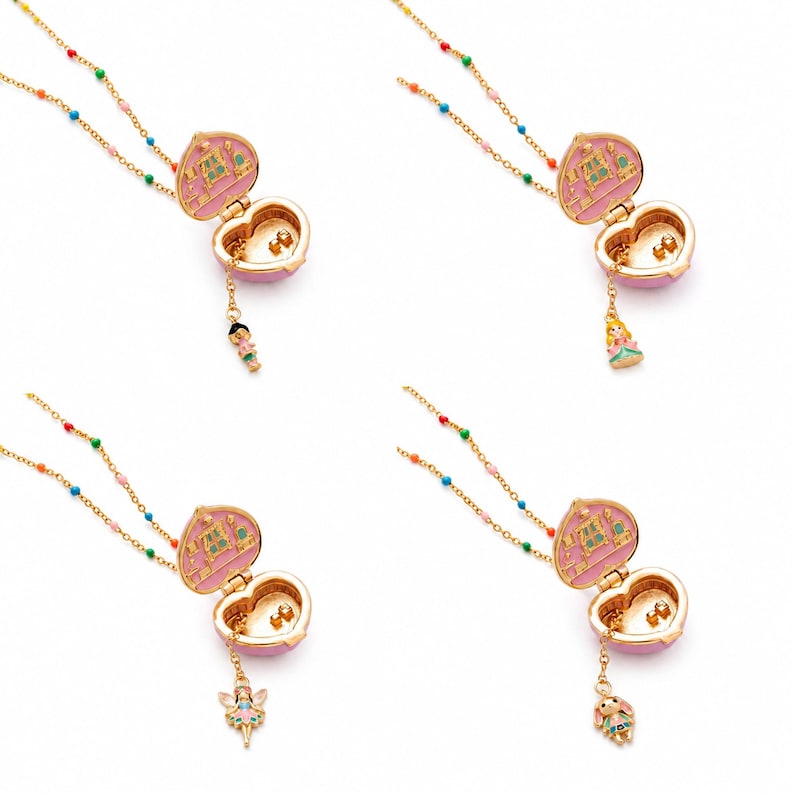 May include: Four gold-tone heart-shaped locket necklaces with pink enamel interiors. Each locket features a different small dangling charm: a person, a princess, a fairy, and a rabbit. The chains are accented with small, colorful beads.
