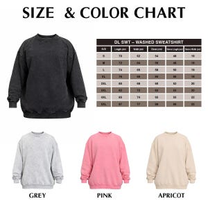 May include: A size and colour chart for a washed sweatshirt, with measurements in centimetres. The image displays a black sweatshirt, along with grey, pink, and apricot coloured sweatshirts. The text on the image reads "SIZE & COLOR CHART".