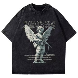 May include: Dark grey short-sleeved t-shirt with a faded effect. The front displays a graphic of an angel with a rifle, accompanied by text. The text includes the words "Peace" and "Freedom".