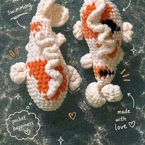 Könnte beinhalten: Zwei handgefertigte Koi-Fische aus Häkelarbeit im Wasser. Die Fische sind weiß mit orangefarbenen und schwarzen Markierungen. Der Text enthält "just keep swimming", "little koi friends", "pocket happiness" und "made with love".