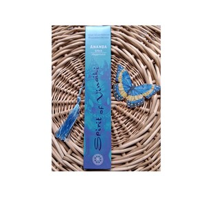 Könnte beinhalten: Eine rechteckige blaue Räucherstäbchenschachtel mit der Aufschrift Ananda Glück Happiness Spirit of Vinaiki und einer hellblauen Quaste an der Seite. Rechts neben der Schachtel befindet sich eine blau-gelbe Schmetterlingsillustration.
