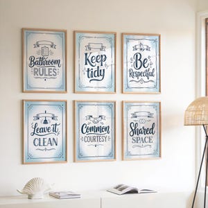 Könnte beinhalten: Sechs gerahmte Kunstdrucke mit Badezimmerregeln an einer weißen Wand. Jeder Druck hat einen hellblauen Hintergrund mit dekorativen Rändern und Text wie "Bathroom Rules", "Keep Tidy" und "Be Respectful". Die Rahmen sind hellbraun.