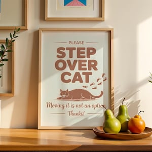 Puede incluir: Una taza de cerámica blanca con un asa negra y el texto "But First, Coffee" en negrita negra. La taza se encuentra sobre un fondo borroso, sugiriendo un ambiente acogedor.