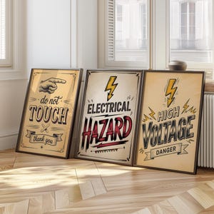 May include: Three framed vintage-style posters with black frames. The posters have a tan background with black and red text. The first poster says "do not TOUCH" with a pointing hand graphic. The second says "ELECTRICAL HAZARD". The third says "HIGH VOLTAGE DANGER".