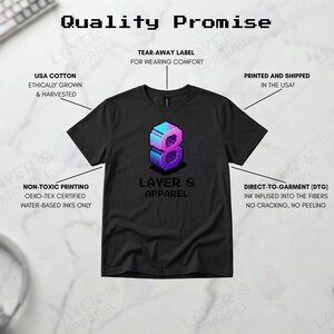 May include: Black t-shirt with a pixelated number 8 graphic in blue and purple, and the text "LAYER 8 APPAREL". The shirt is made with USA cotton and non-toxic printing.