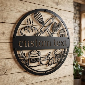 Könnte beinhalten: Schwarzes Metall-Rundschild mit Backmotiven, darunter ein Brot, ein Schneebesen, eine Teigrolle, Weizen, ein Cupcake, ein Mehlsack, eine Schüssel und ein Croissant. Das Schild trägt die Aufschrift "custom text".